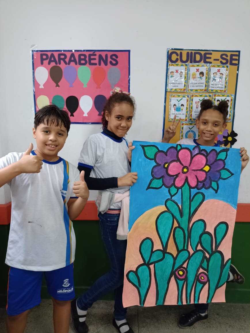 Alunos exibindo painel com cactos e flores